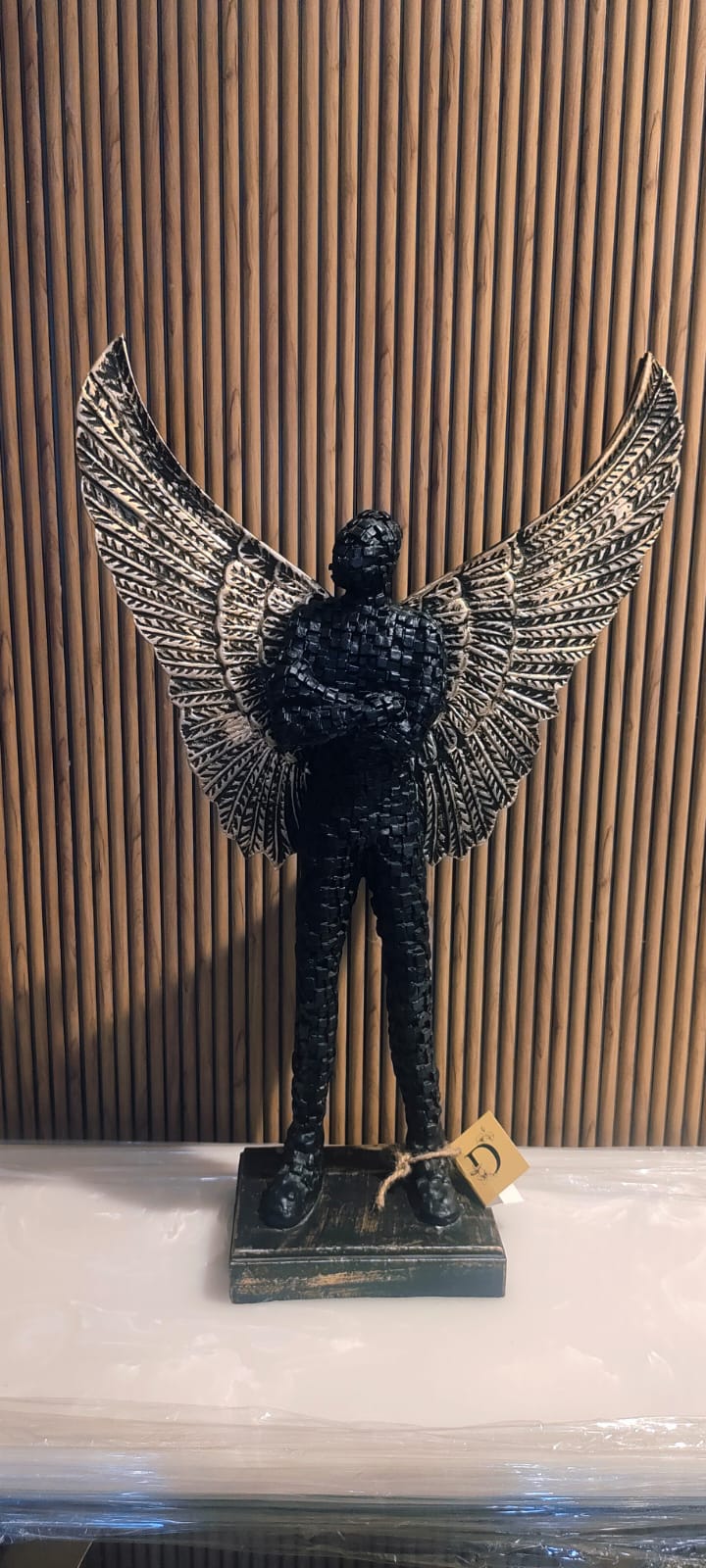 A Bold And Artistic Sculpture Of A Standing Human Figure With Detailed Wings Extended