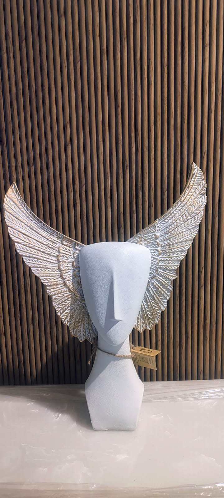 Modern Abstract Sculpture Of A Faceless Human Bust With Large, Intricately Detailed Golden Wings Extending Outward