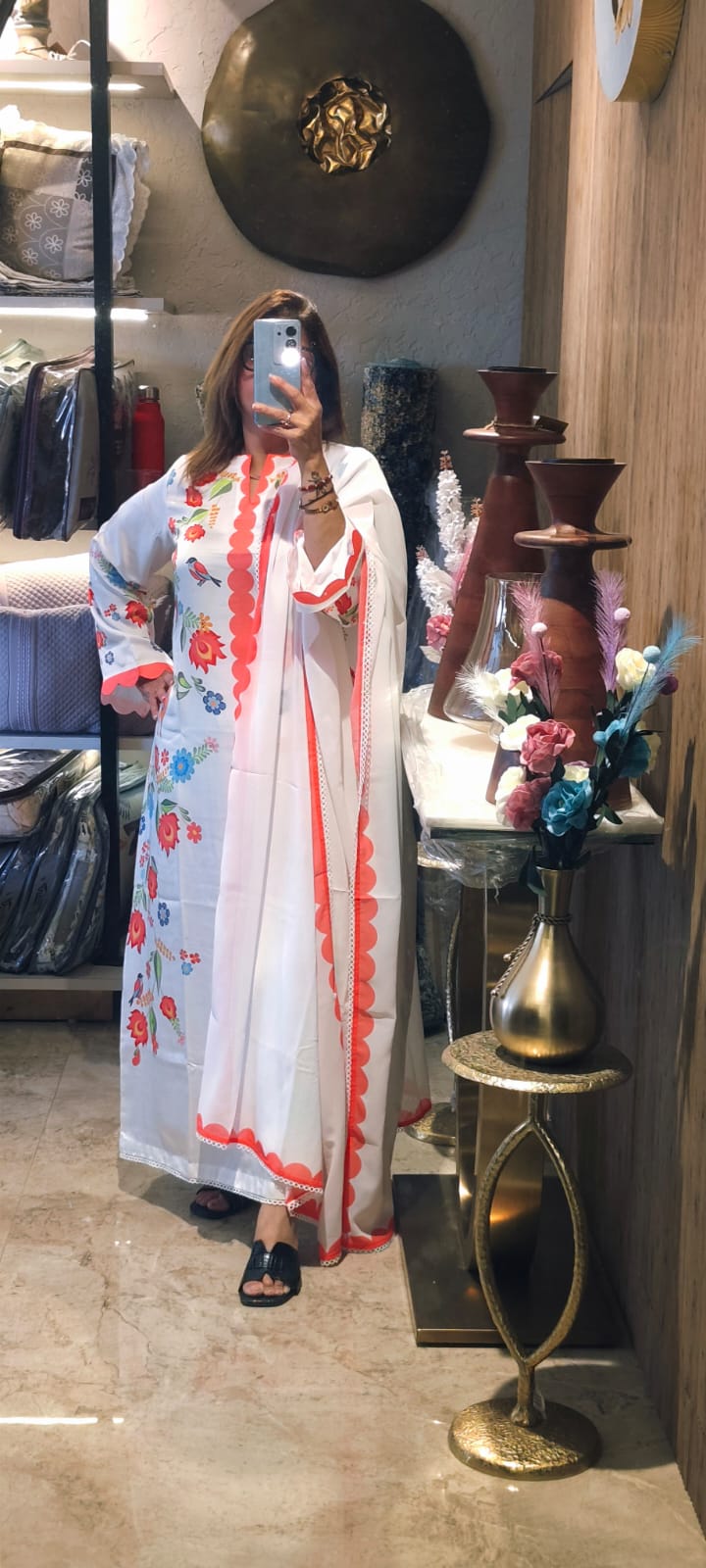 This Outfit Features A Graceful, Semi-Formal Traditional Look With A White Base Accented By Vibrant Floral Prints And Bold Coral Details.