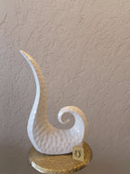 A Modern Abstract Ceramic Sculpture Featuring A Sleek, Spiral Horn-Like Design With A Hammered Texture In Glossy White Finish.