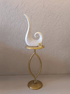A Modern Abstract Ceramic Sculpture Featuring A Sleek, Spiral Horn-Like Design With A Hammered Texture In Glossy White Finish.