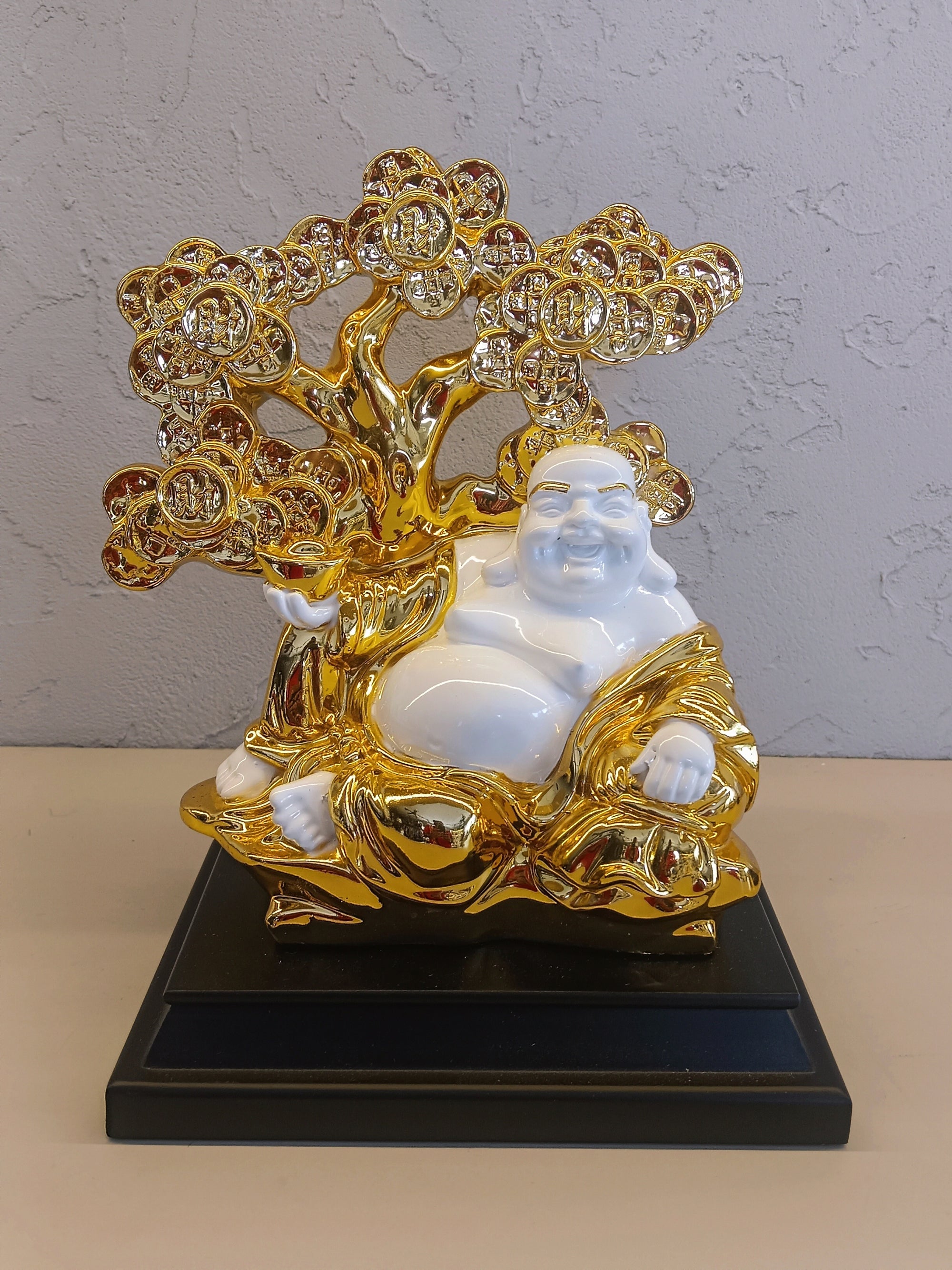 A Decorative Figurine Featuring A White And Gold Representation Of The Laughing Buddha
