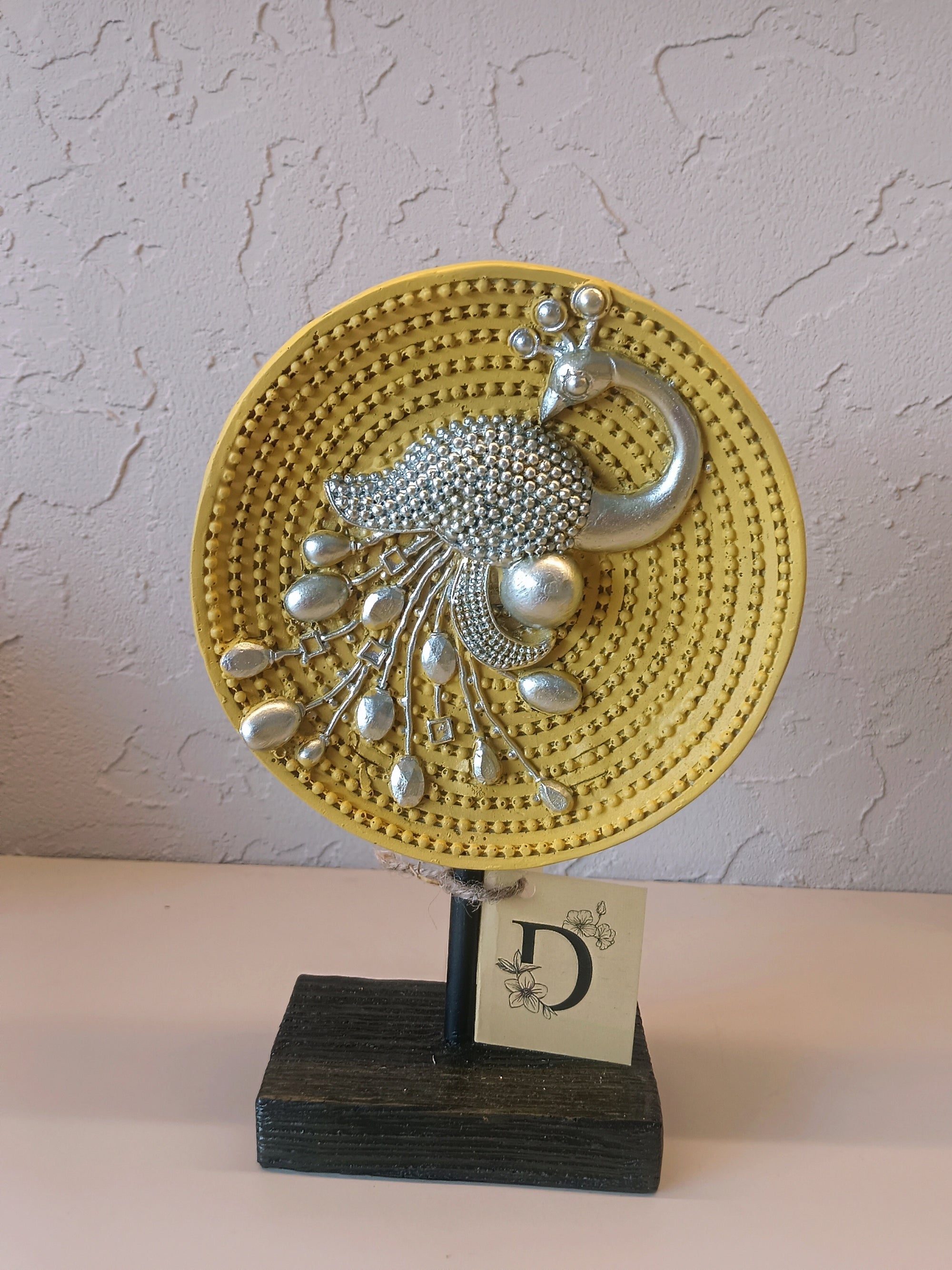 Decorative Peacock Figurine Mounted On A Round Yellow Textured Plate With Intricate Silver Detailing