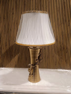 Elegant Table Lamp With A Golden Metallic Base Featuring Intricate Floral Dine Detailing