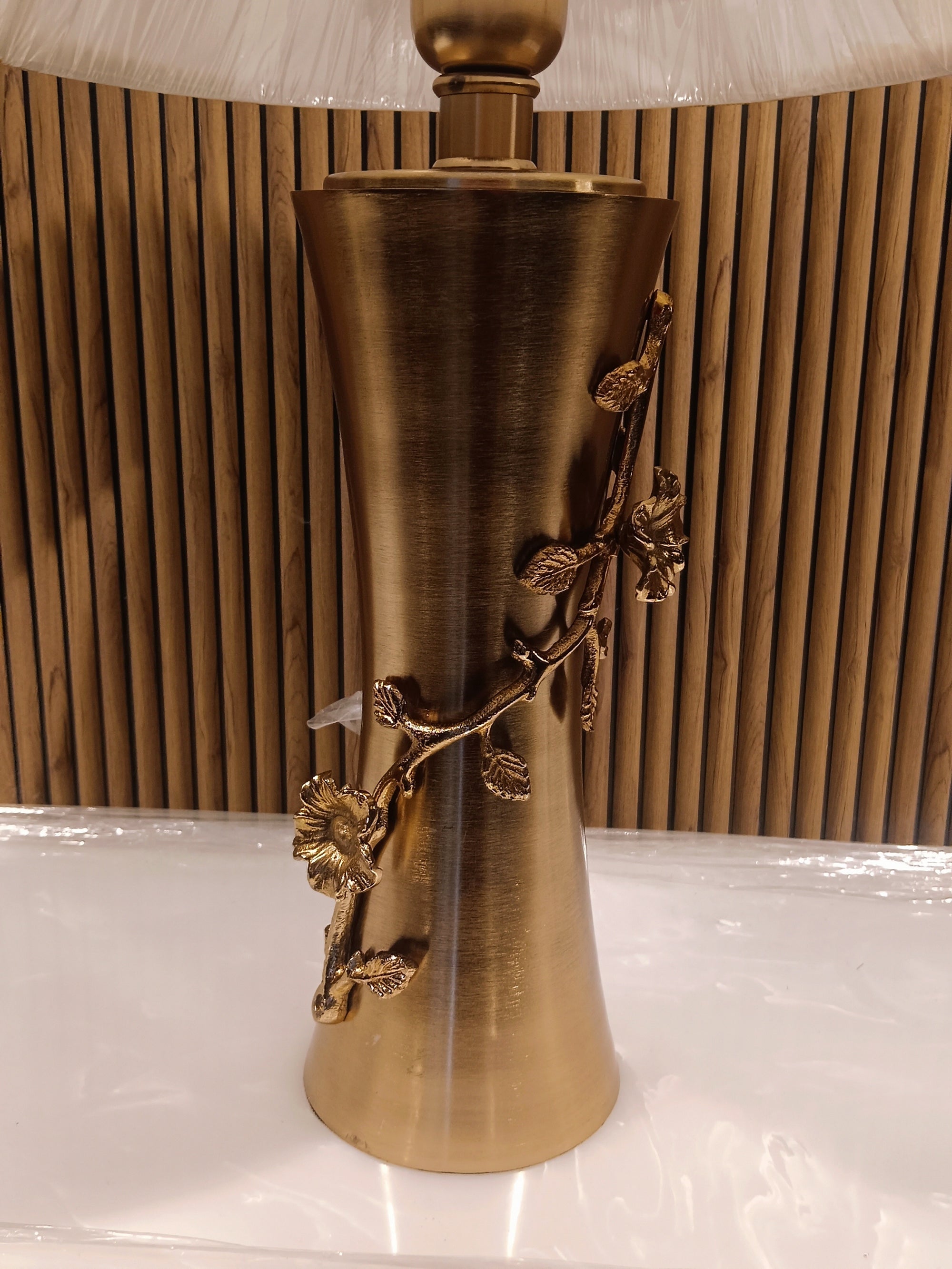 Elegant Table Lamp With A Golden Metallic Base Featuring Intricate Floral Dine Detailing