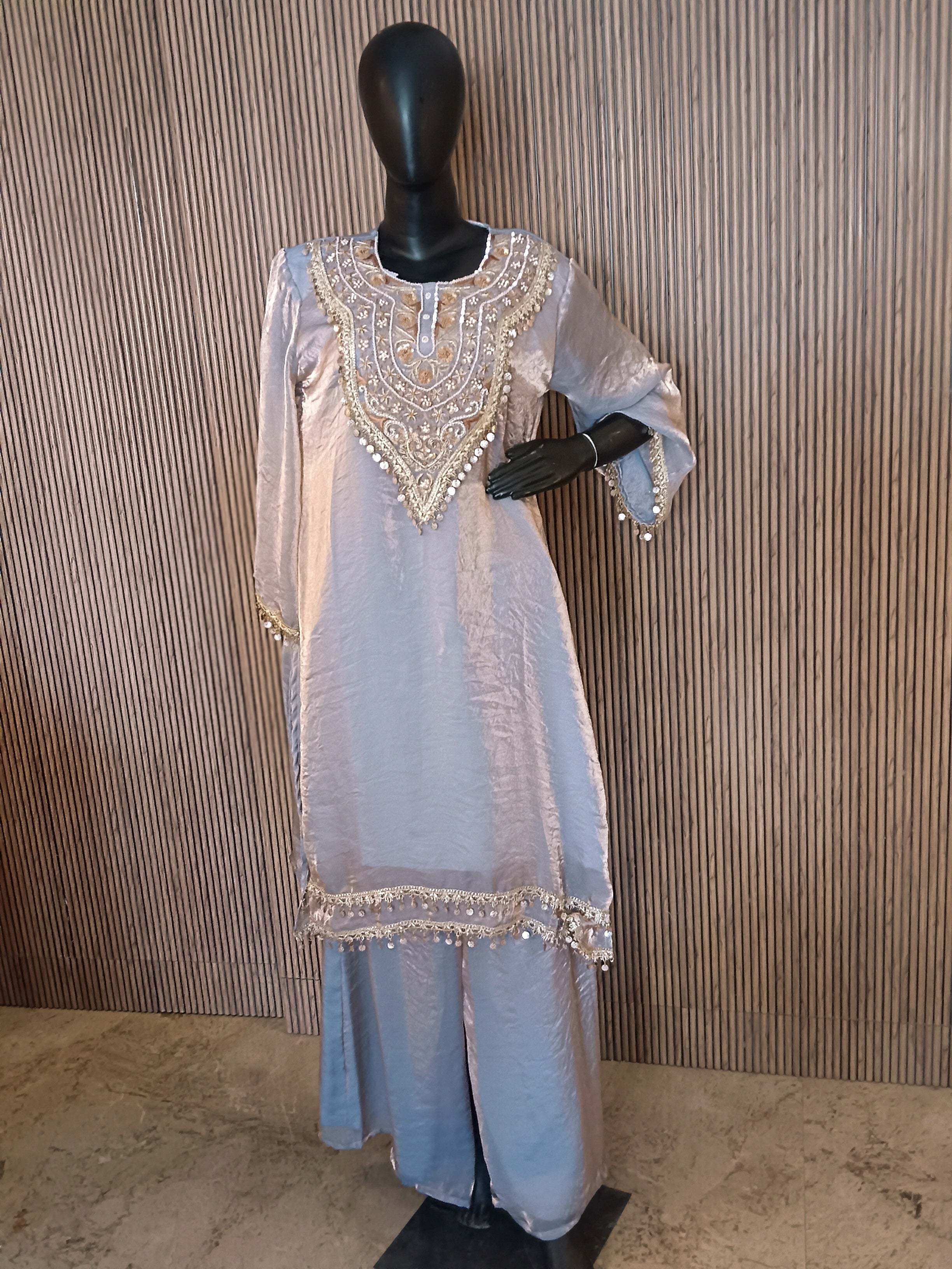 This Elegant Ensemble Features A Shimmering Light Gray Kurti With Luxurious Gold And Silver Embroidery At The Neckline, Sleeves