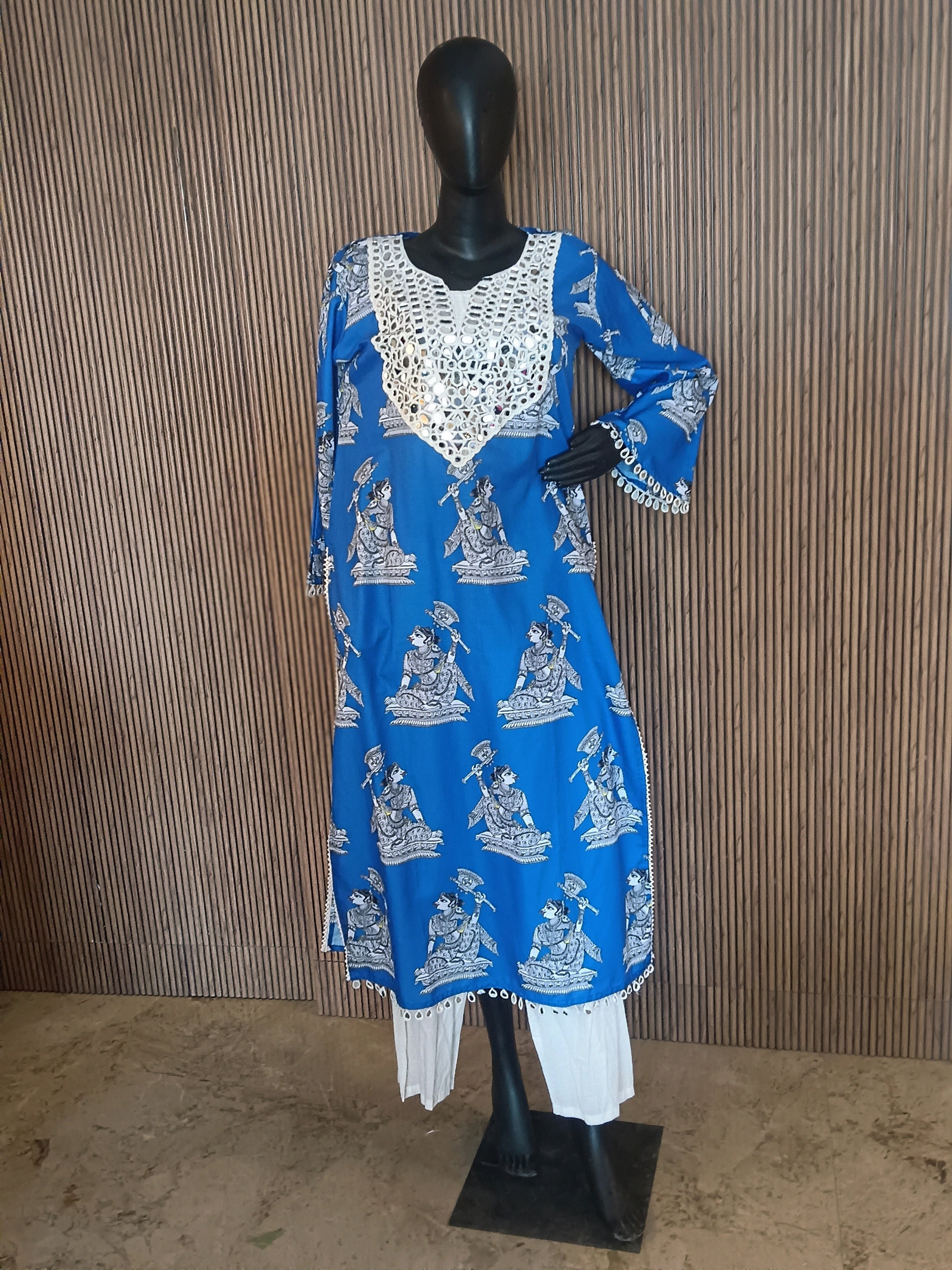 A Vibrant Blue Printed Kurti Featuring Intricate White Mirror-Work Embroidery On The Neckline And Cuffs, Paired With Flowy White Palazzo Pants