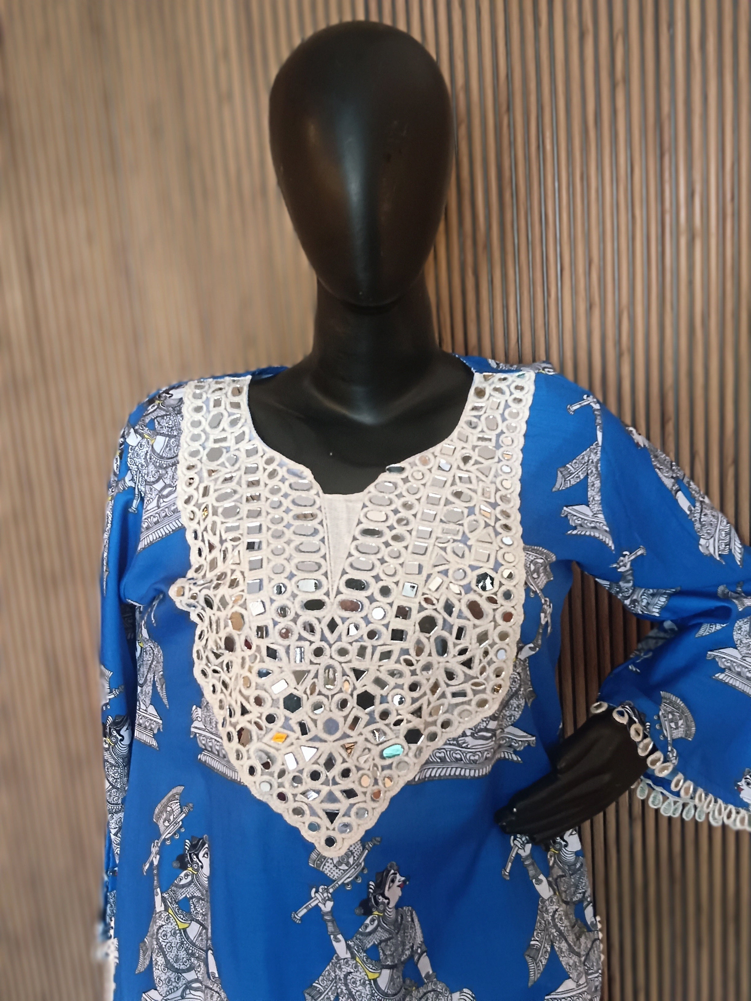 A Vibrant Blue Printed Kurti Featuring Intricate White Mirror-Work Embroidery On The Neckline And Cuffs, Paired With Flowy White Palazzo Pants
