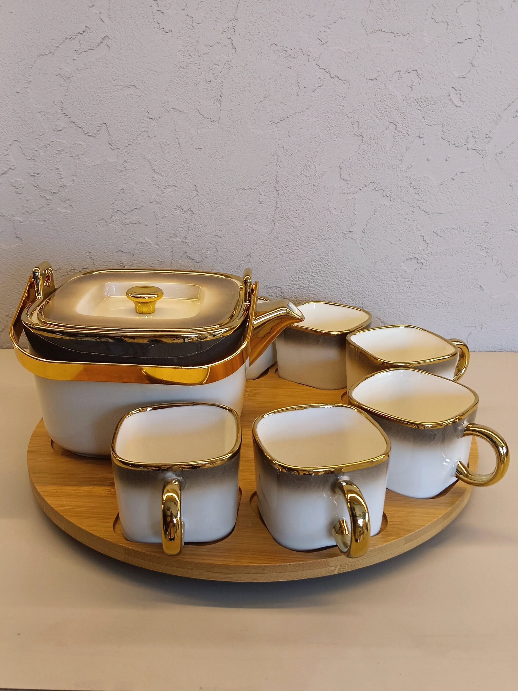 Luxurious Ceramic Tea/Coffee Set With Golden Detailing, Featuring A Teapot, And A Rotating Wooden Base Tray