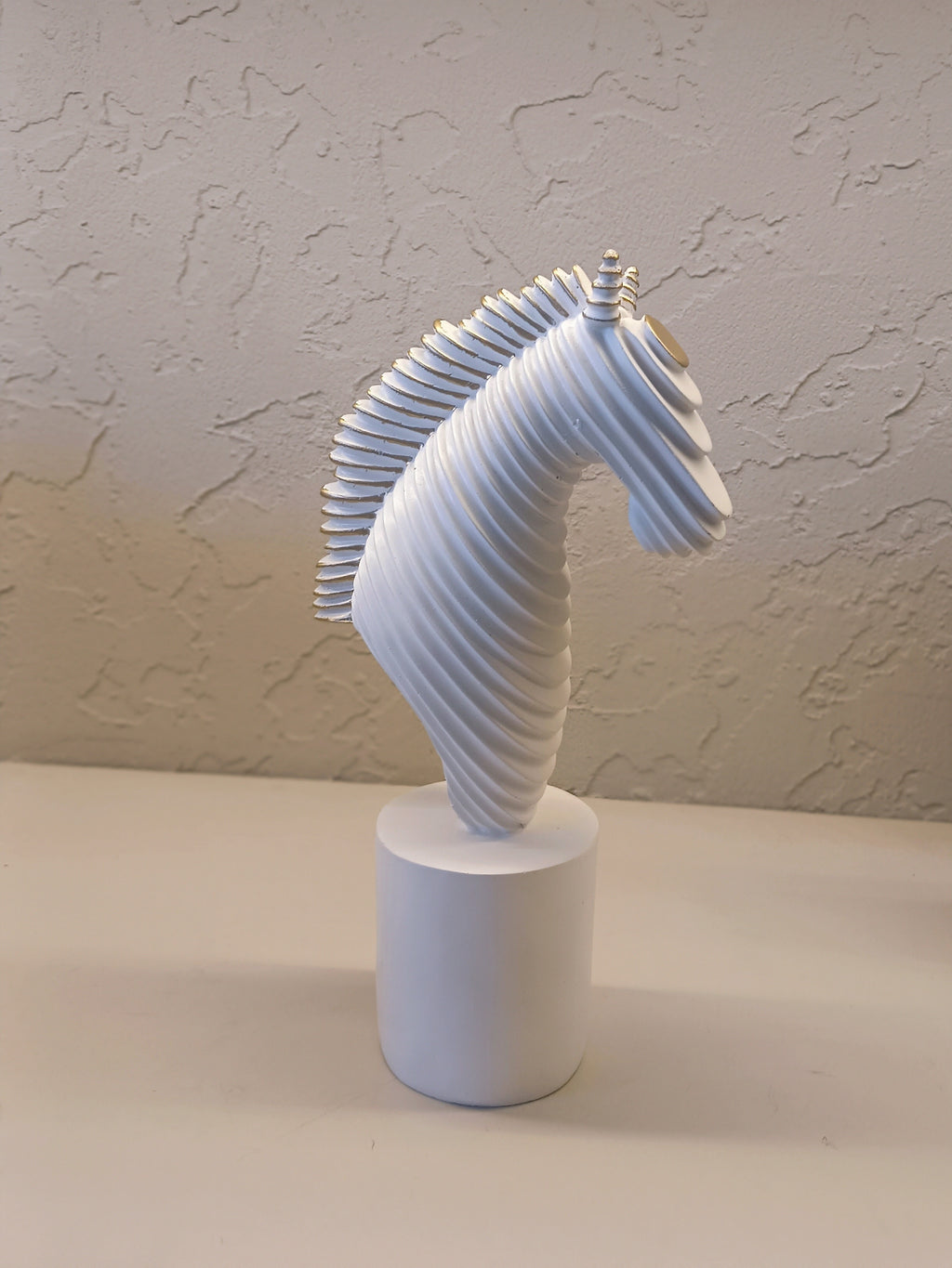 A Modern Abstract Sculpture Of A Horse Head In White With Golden Accents