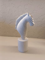 A Modern Abstract Sculpture Of A Horse Head In White With Golden Accents