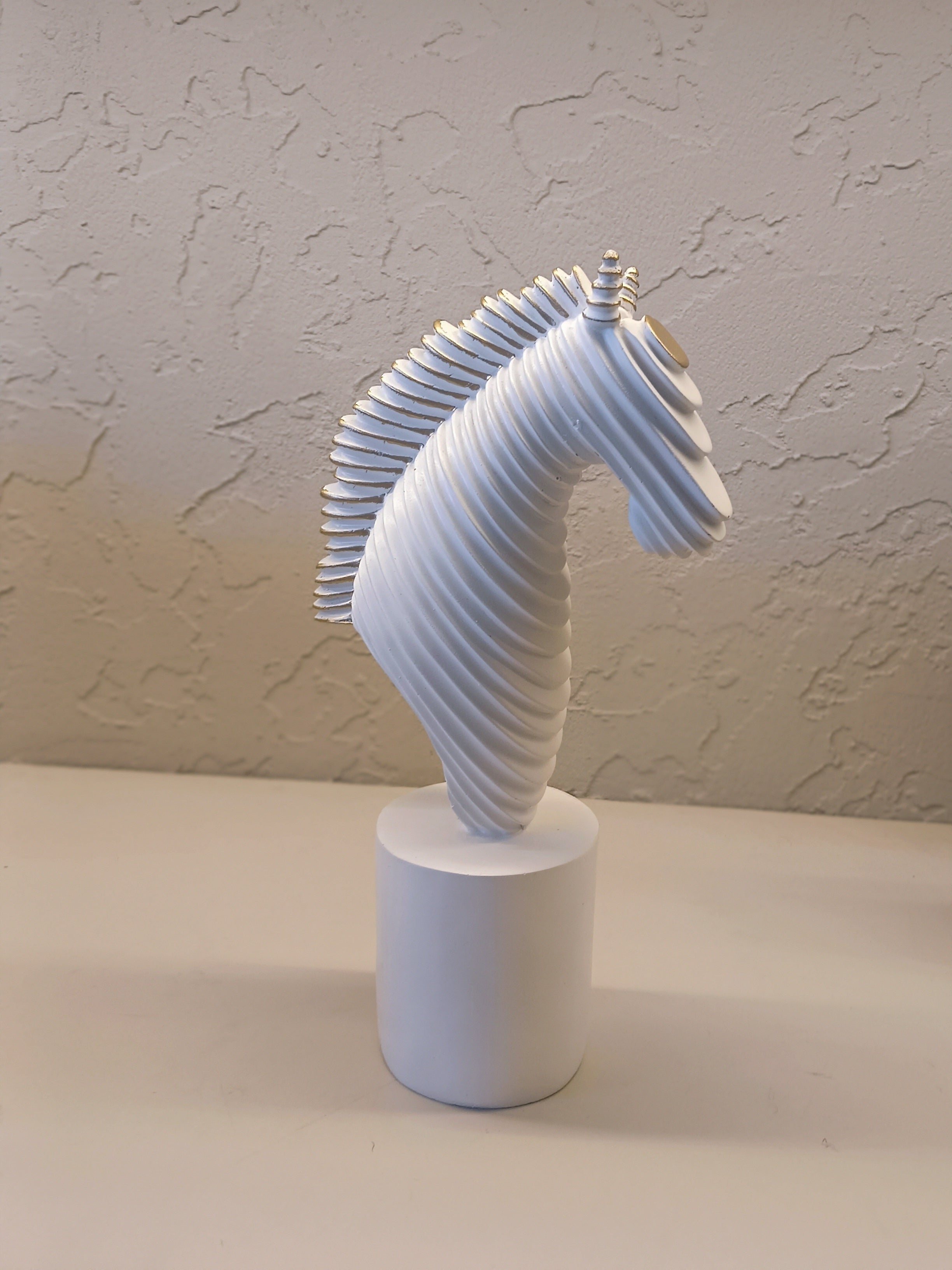 A Modern Abstract Sculpture Of A Horse Head In White With Golden Accents