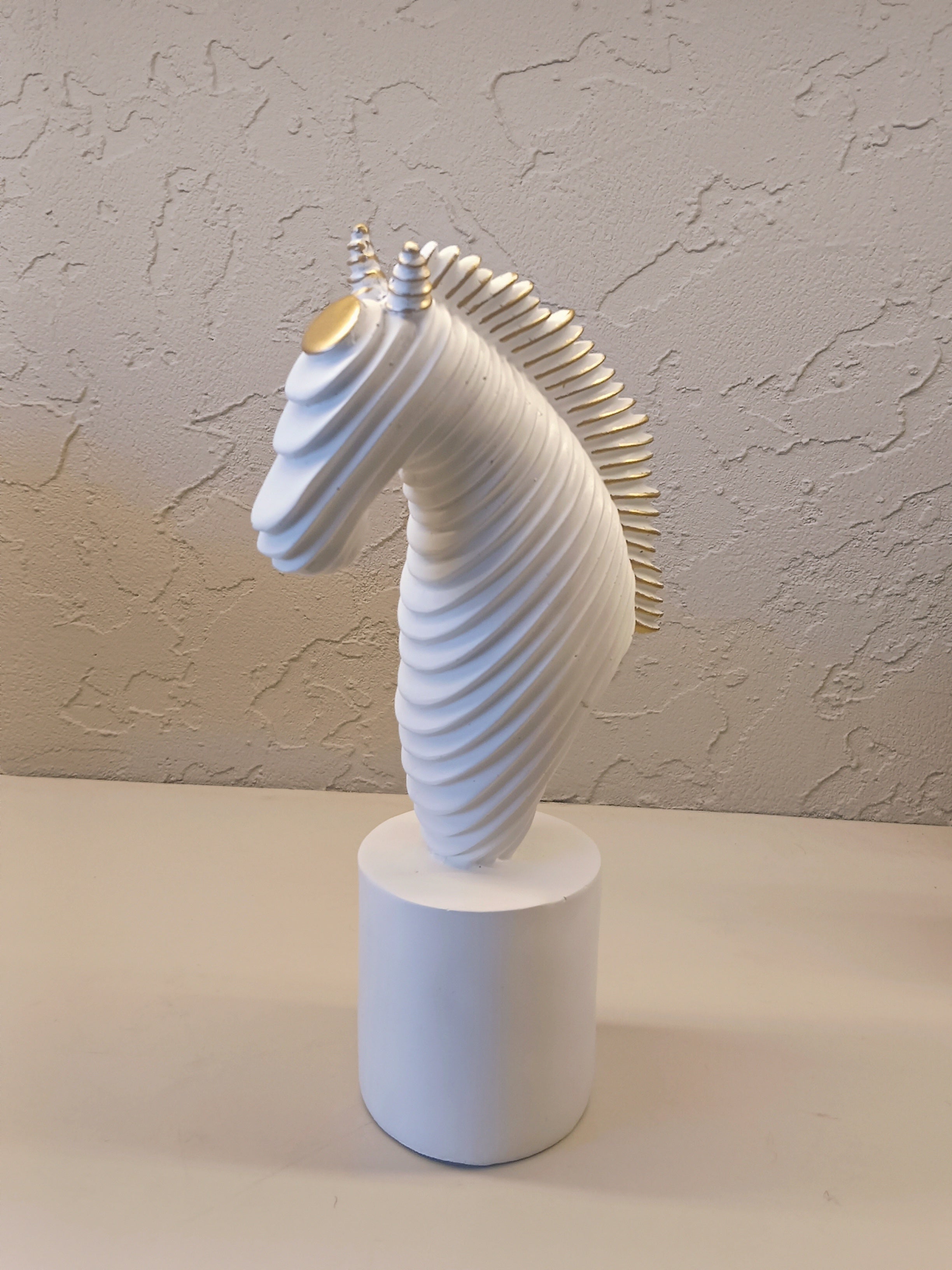 A Modern Abstract Sculpture Of A Horse Head In White With Golden Accents