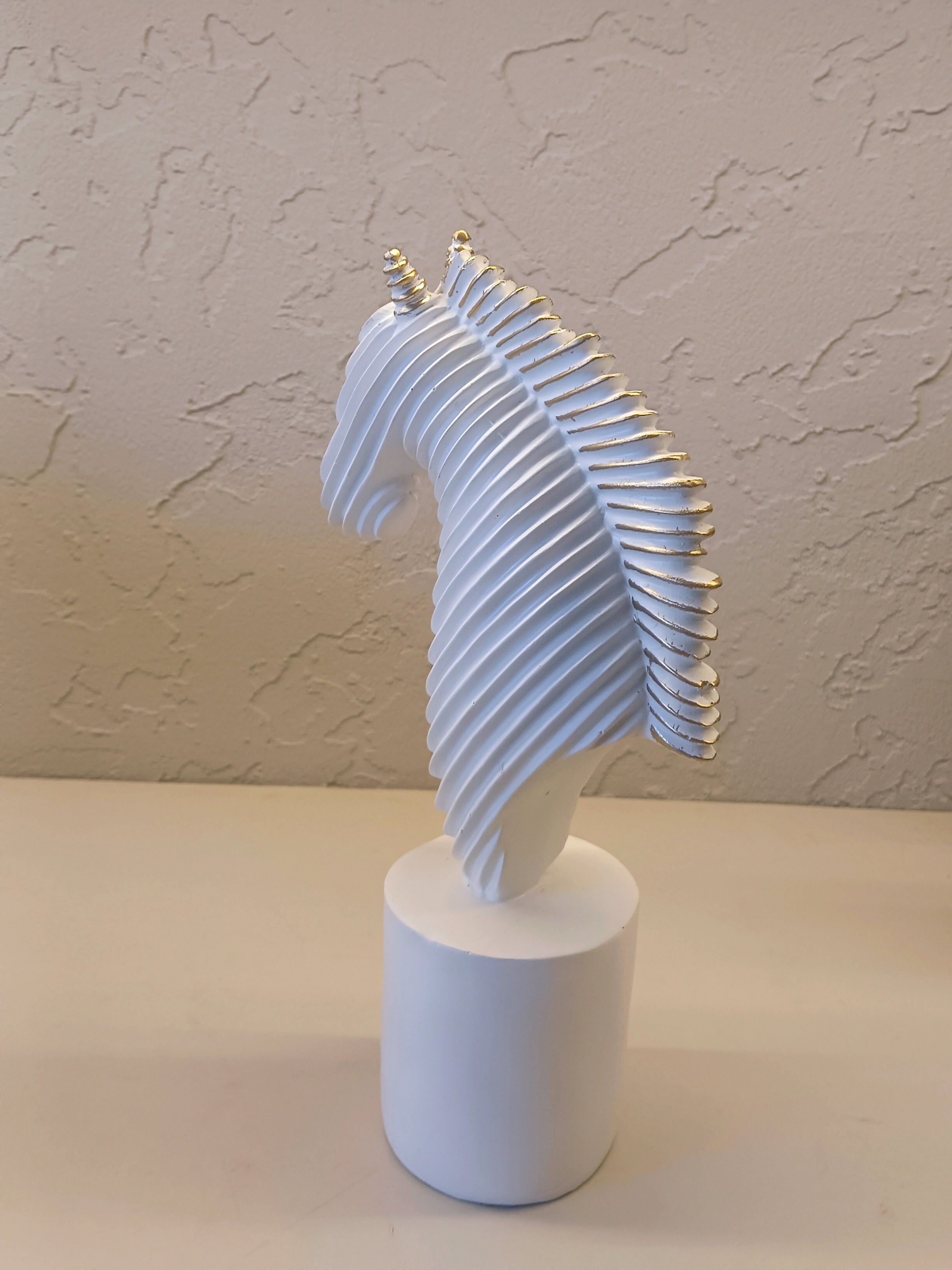 A Modern Abstract Sculpture Of A Horse Head In White With Golden Accents
