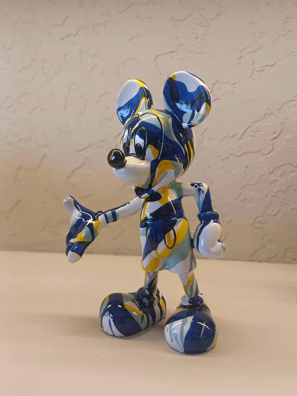 A Vibrant Artistic Figurine Of Mickey Mouse, Designed With An Abstract Splash Pattern