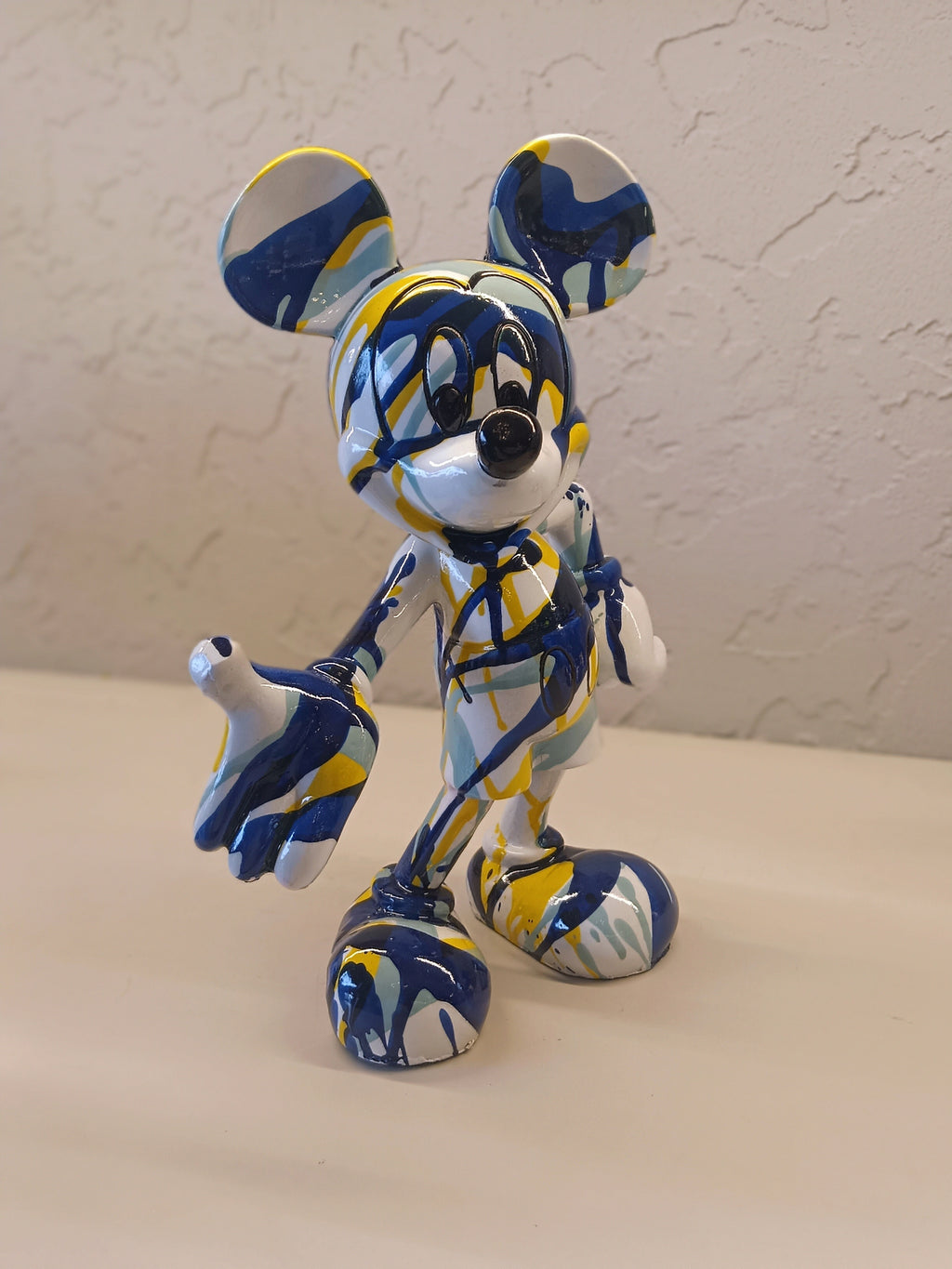 A Vibrant Artistic Figurine Of Mickey Mouse, Designed With An Abstract Splash Pattern