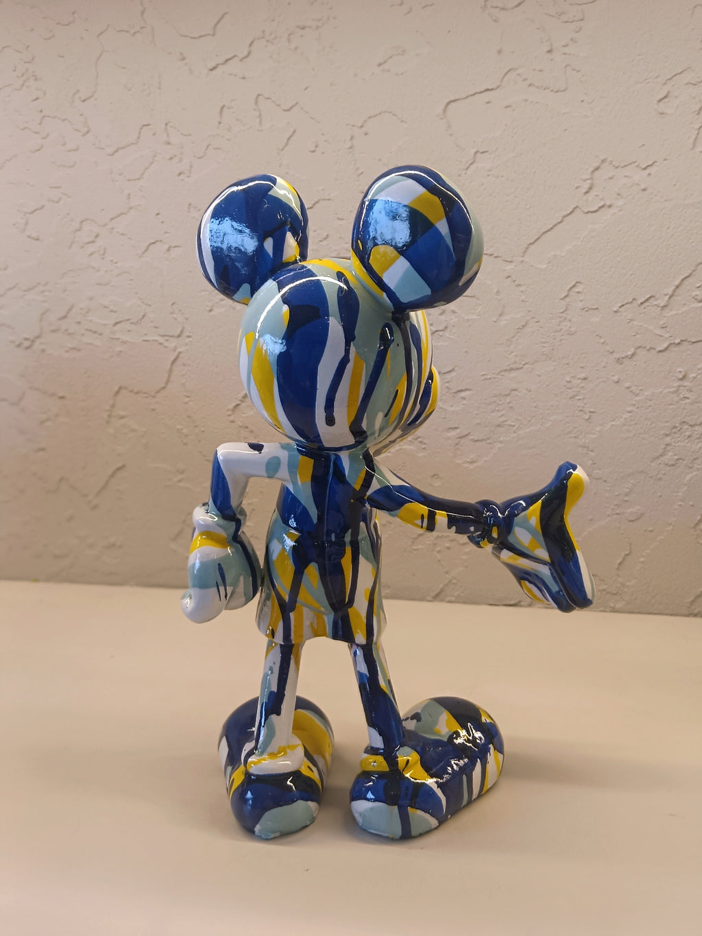 A Vibrant Artistic Figurine Of Mickey Mouse, Designed With An Abstract Splash Pattern