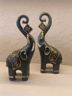 A Pair Of Intricately Crafted Decorative Elephant Figurines With Trunks Raised High, Symbolizing Prosperity