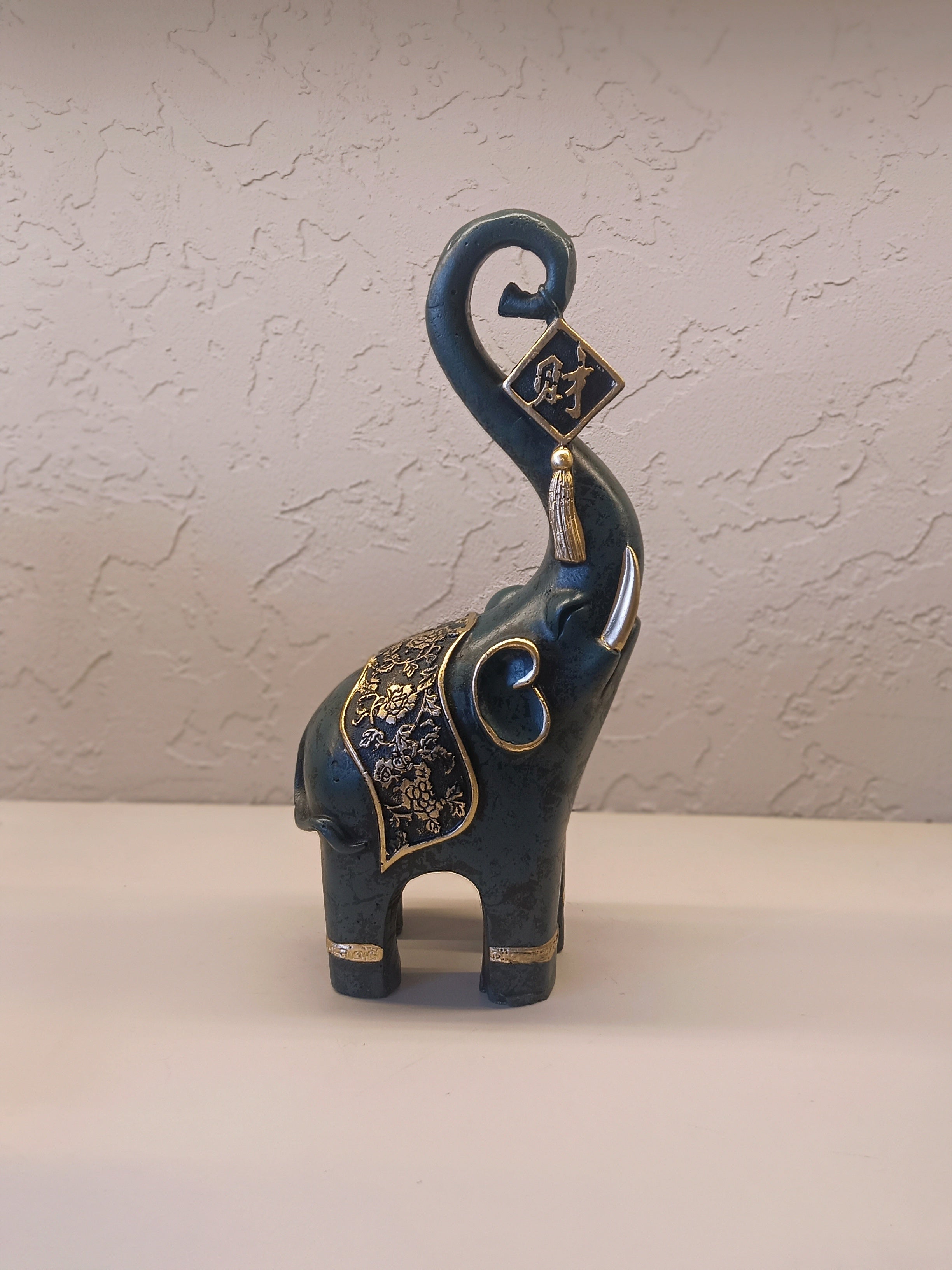 A Pair Of Intricately Crafted Decorative Elephant Figurines With Trunks Raised High, Symbolizing Prosperity