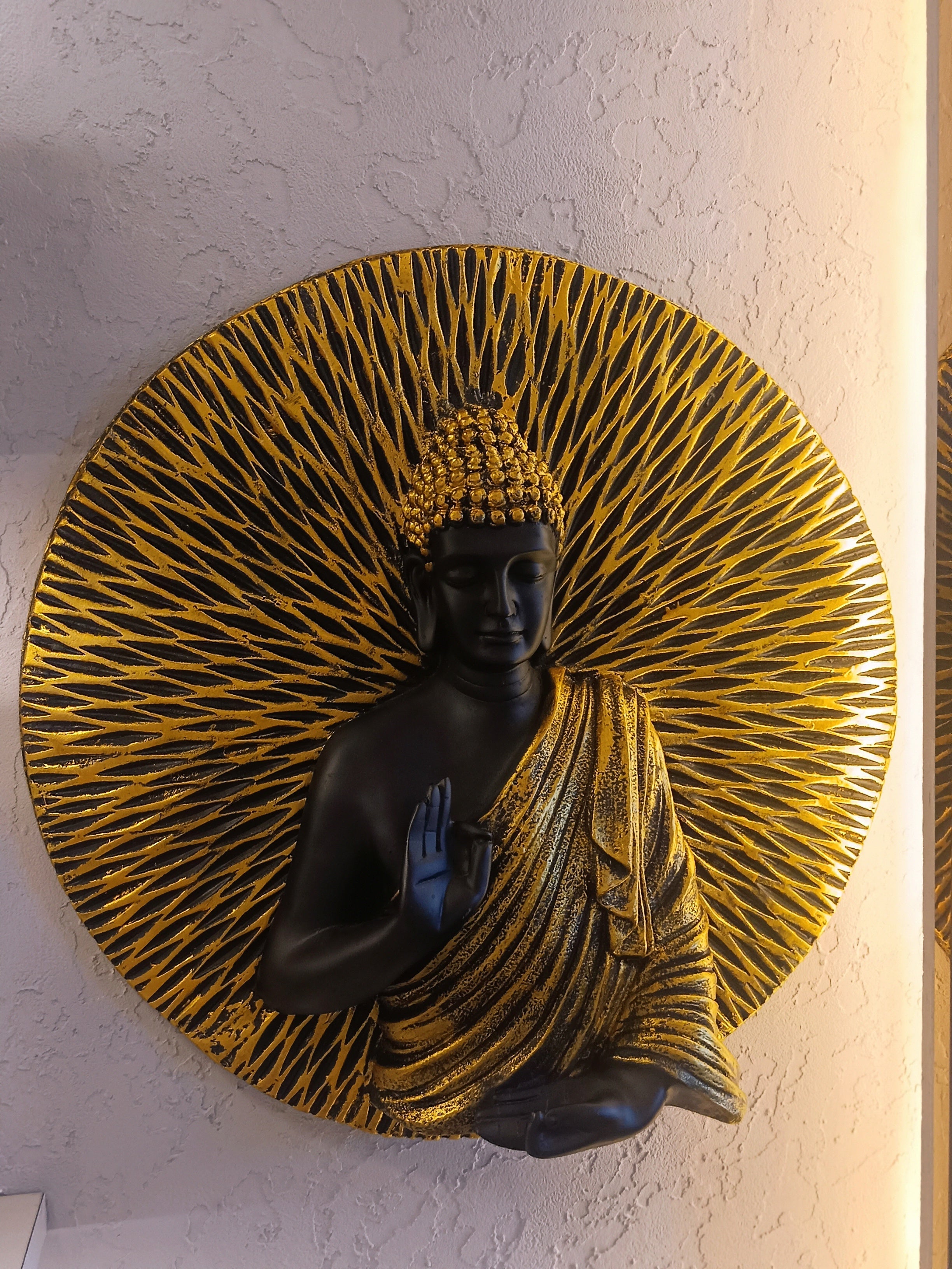 Decorative Wall Sculpture Of Buddha Rendered In Black And Gold, With A Radiant Circular Pattern