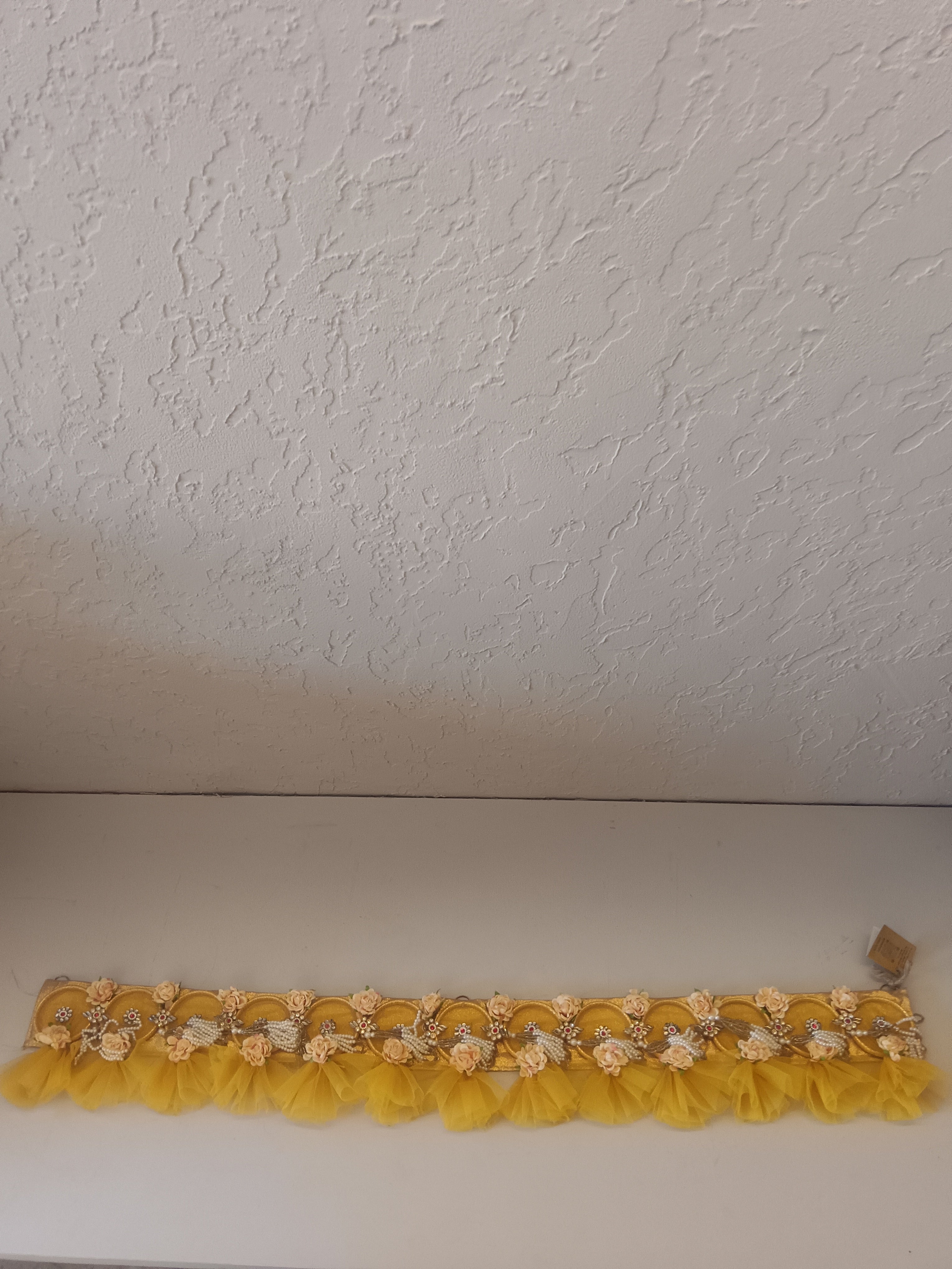 A Vibrant Yellow Decorative Band Adorned With Artificial Flowers, Beads, And Fabric Accents
