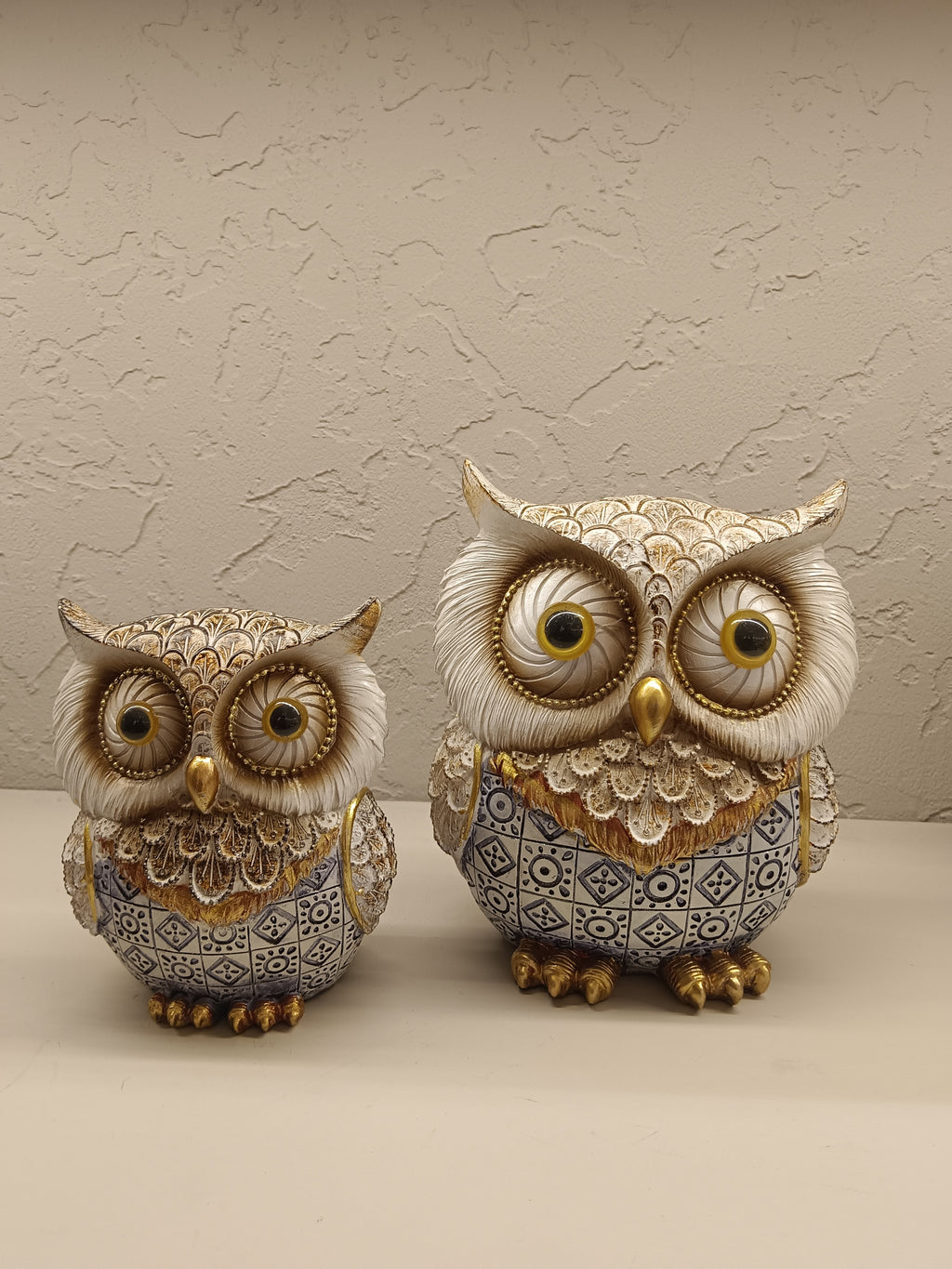 Elegant decorative owl figurines crafted with intricate detailing and a combination
