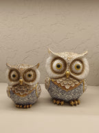 Elegant decorative owl figurines crafted with intricate detailing and a combination