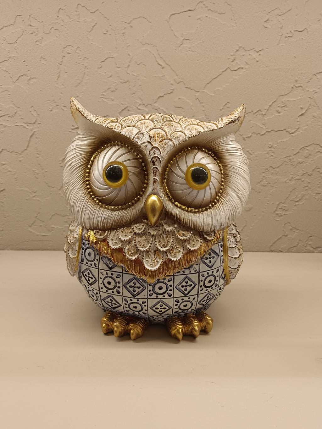 Elegant decorative owl figurines crafted with intricate detailing and a combination