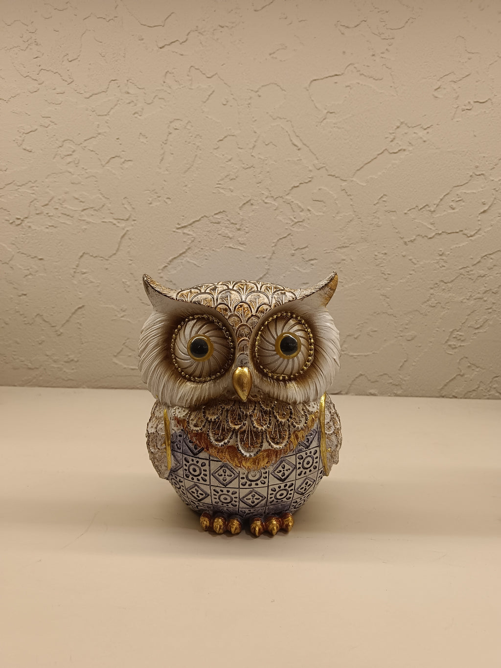 Elegant decorative owl figurines crafted with intricate detailing and a combination