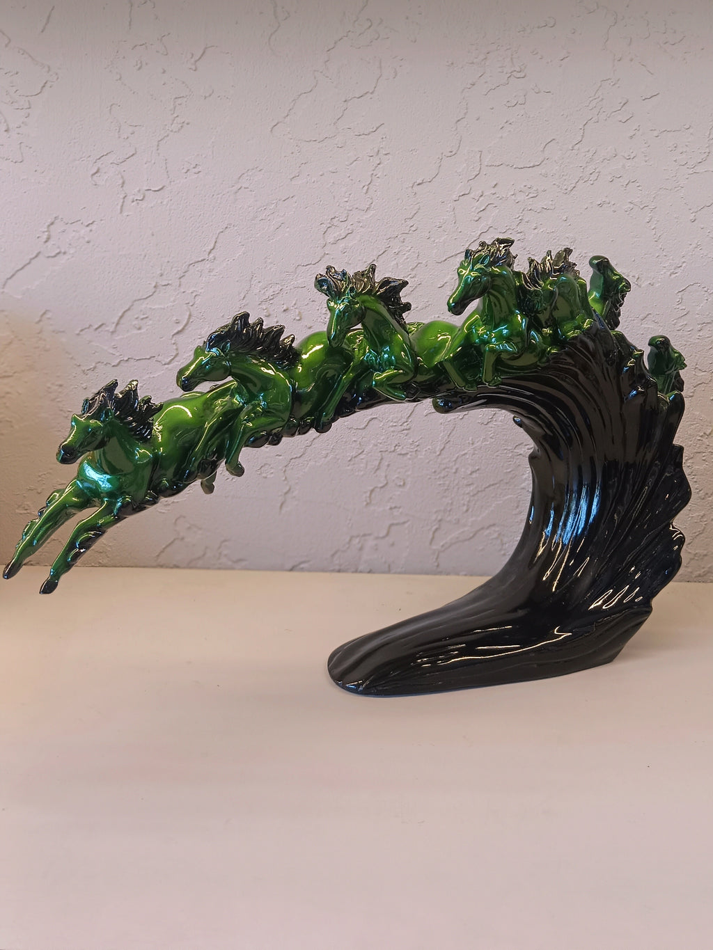 Dynamic and artistic sculpture of running horses, designed with a glossy green and black
