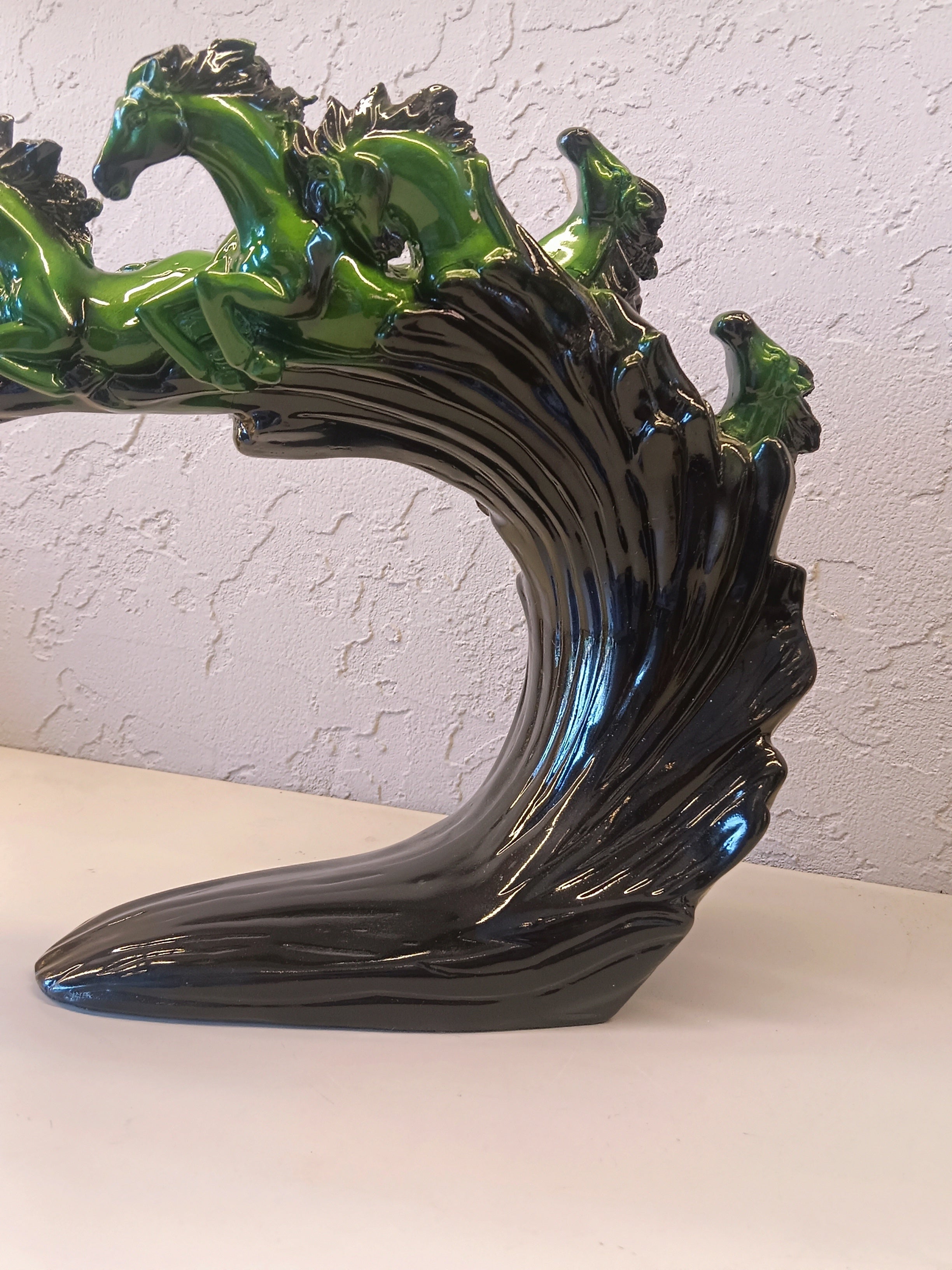 Dynamic and artistic sculpture of running horses, designed with a glossy green and black