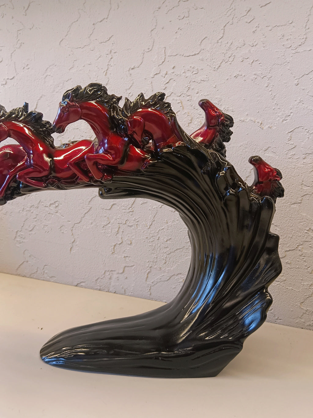 Dynamic and artistic sculpture of running horses, designed with a glossy maroon and black