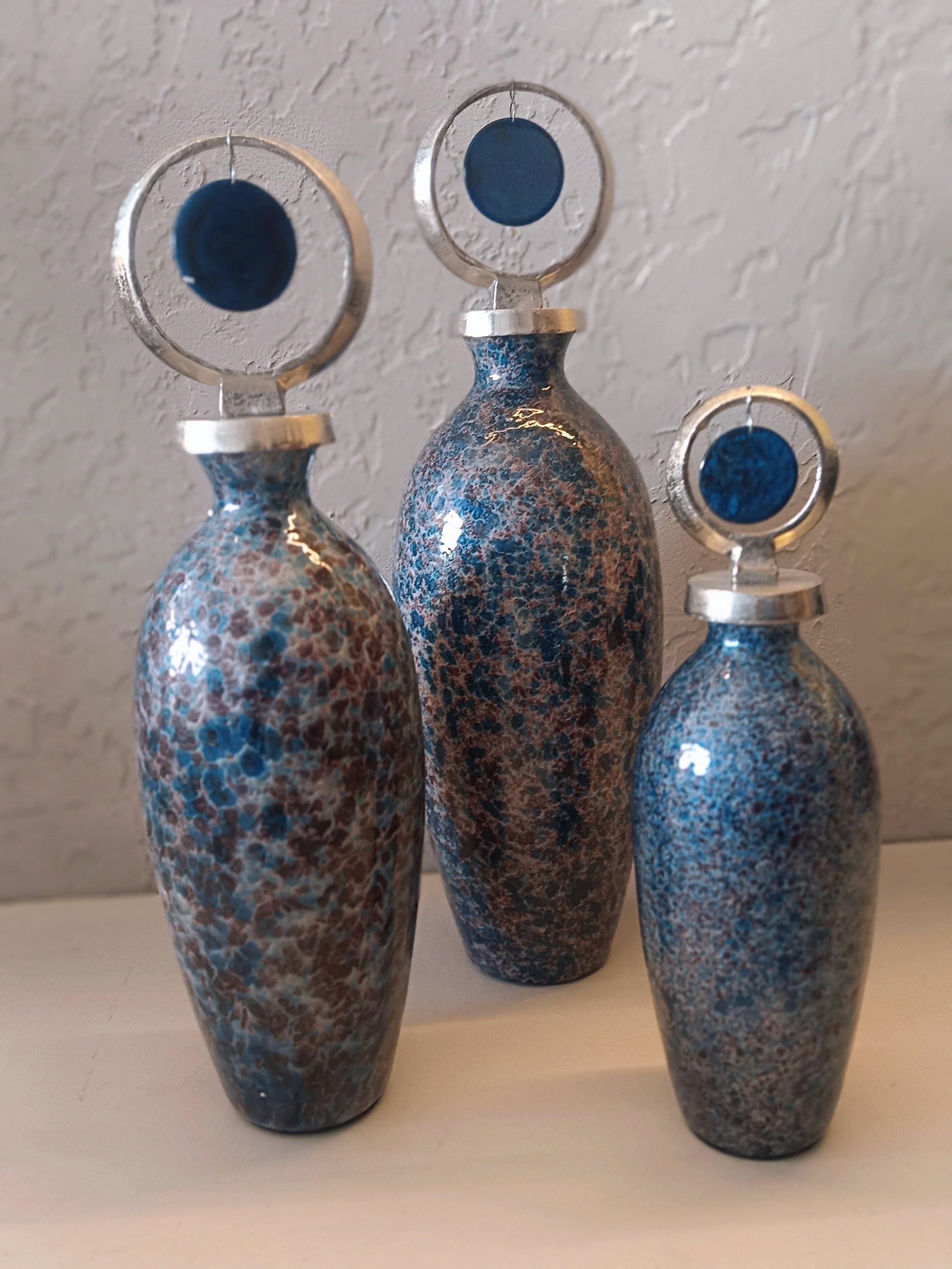A STUNNING TRIO OF METAL DECORATIVE VASES FEATURING A SPECKLED BLUE AND BROWN GLAZE FINISH