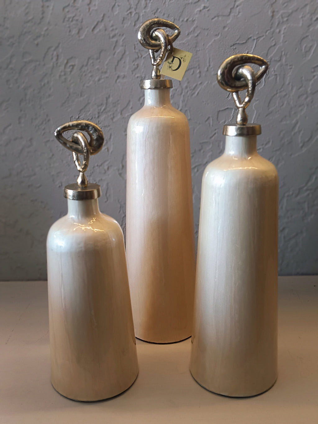 A STYLISH SET OF THREE CONTEMPORARY DECORATIVE VASES IN A GLOSSY BEIGE-CREAM TONE