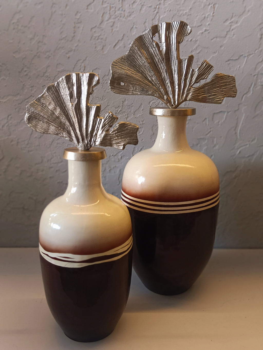 A PAIR OF ELEGANT DECORATIVE METAL VASES FEATURING A GLOSSY TWO-TONE FINISH