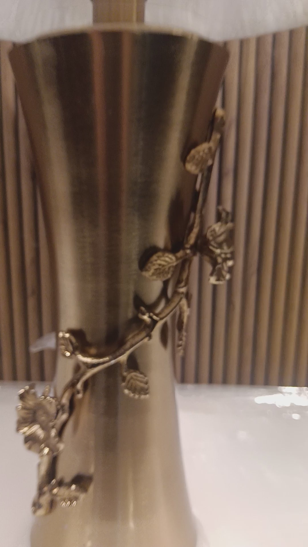 Elegant Table Lamp With A Golden Metallic Base Featuring Intricate Floral Dine Detailing