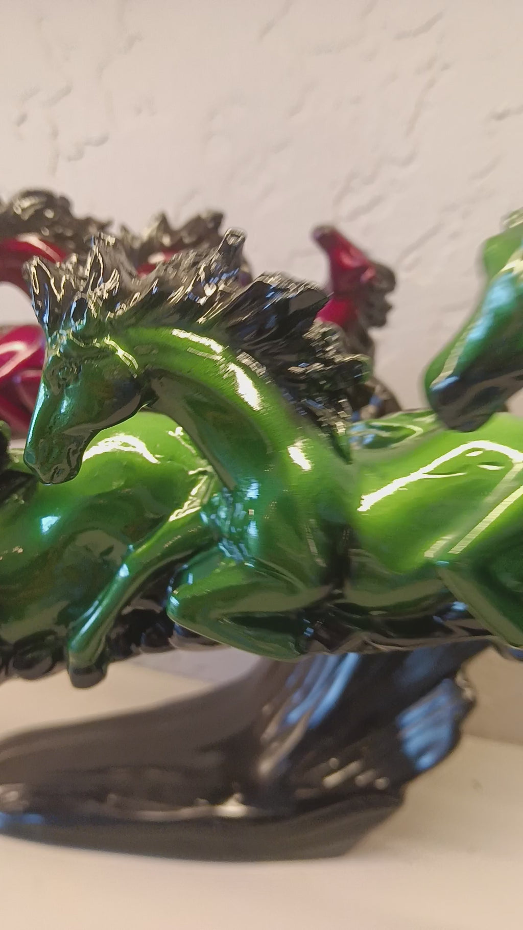 Dynamic and artistic sculpture of running horses, designed with a glossy maroon and black